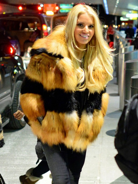 JESSICA SIMPSON in a fur-collared coat, at JFK Airport, in New York City